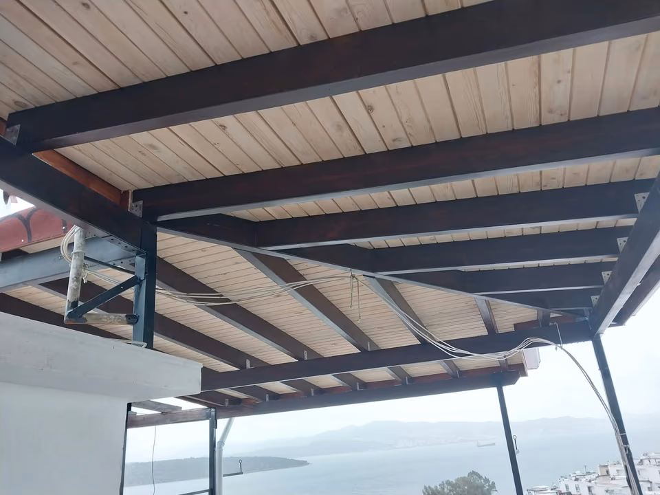 Açık tavan kaplaması ve koyu renkli veranda kirişleri