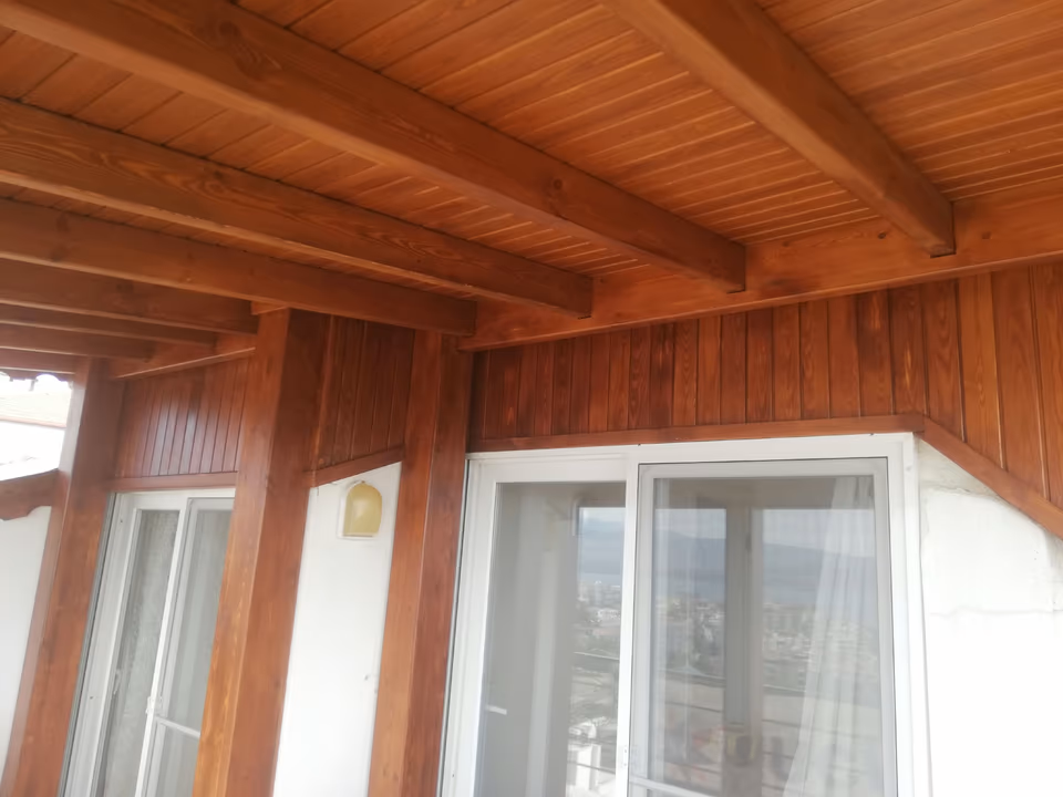 Verandada ahşap kirişler, tavan kaplaması ve dikme birleşimi