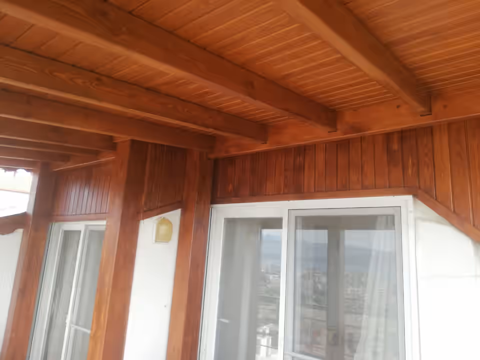 Verandada ahşap kirişler, tavan kaplaması ve dikme birleşimi