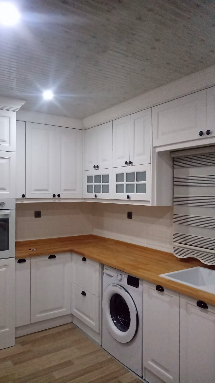 Camlı üst dolaplarla ahşap tezgâhlı mutfak