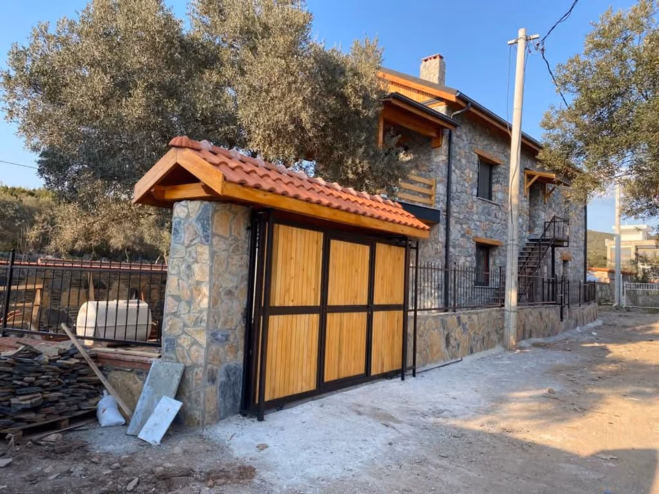 Taş duvar içinde ahşap panelli bahçe kapısı