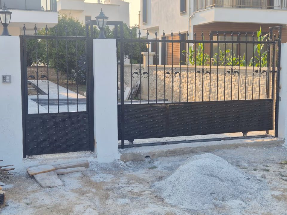Bahçe girişinde dikey demir çubuklu kapı
