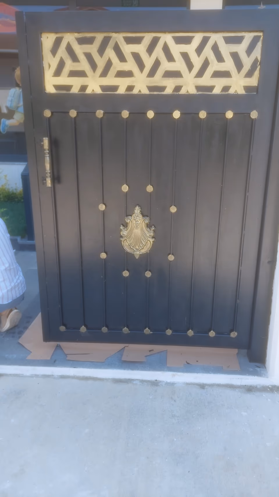 Altın tonlu motiflerle siyah metal giriş kapısı