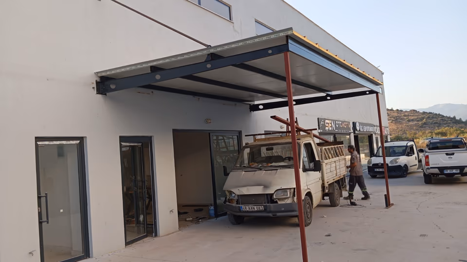 Araç girişinde metal dikmeli sundurma